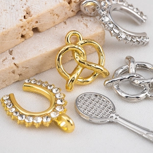Gros plan de pendentifs bretzel et raquette de tennis avec cristaux incrustés