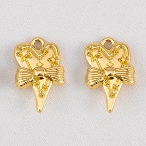 Gros plan de pendentifs coeur dorés avec nœud et étoile pour bijoux DIY créatifs
