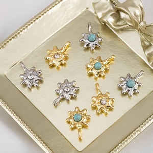 Detailed macro view of gold and silver hexagram pendants with inlaid zircon and turquoise
