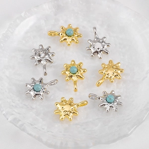 Golden and silver sun pendants with crystals and turquoise on a textured glass tray