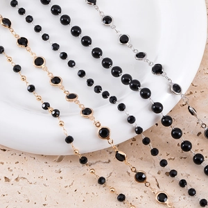 Detailed close-up of 3-8mm black beaded copper chain with gold and silver metal accents