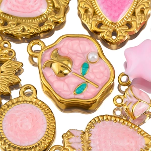 Vue macro de pendentifs cœur en émail rose pour création de bijoux DIY dorés