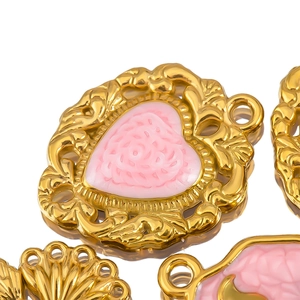 Vue macro d'un pendentif cœur en résine rose avec bords dorés en relief au style vintage