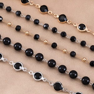 Detail of four black bead and gemstone jewelry chains with gold and silver finishes