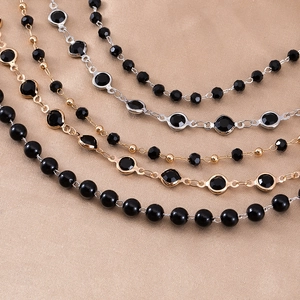 Macro detail of 3-8mm black bead and crystal jewelry chains with gold silver frames