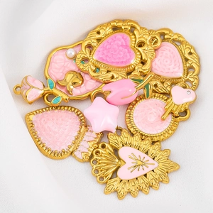 Détail de pendentifs en émail rose et or avec des motifs de roses et de cœurs