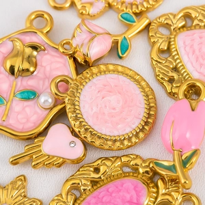 Détail de breloques en émail rose avec perles et strass sur base en acier doré