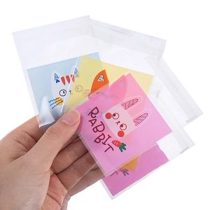 Detalle de pequeñas bolsas adhesivas transparentes con tarjetas de animales para joyas y dulces