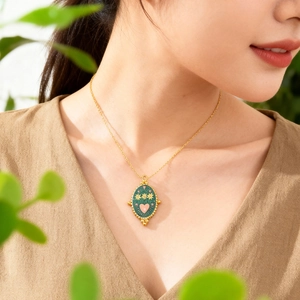 Vintage green oval flame eye pendant necklace with gold floral details and a pink heart center