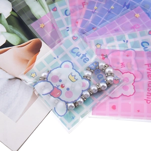 Detalle de bolsas de joyería con dibujos de osos y pulsera decorativa de perlas blancas