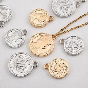 Dettaglio macro di ciondoli a moneta vintage con rilievo della regina in oro e argento