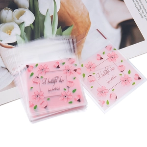 Dettaglio di sacchetti richiudibili con stampa di ciliegio rosa e scritte a mano decorative