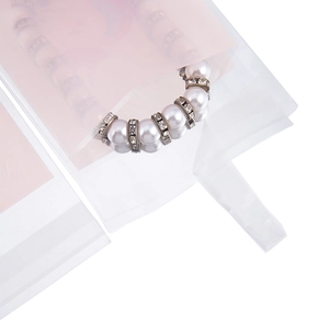 Dettaglio bracciale di perle in confezione opaca traslucida con inserto rosa decorativo