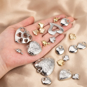 Assortimento di ciondoli a cuore in oro e argento per gioielli fai da te su raso