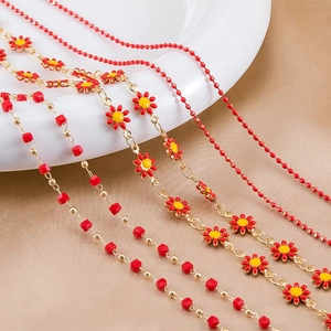 Detail of red enamel daisy chains and gold beaded jewelry links for DIY necklaces