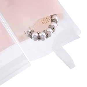 Dettaglio confezione rosa con bracciale di perle bianche e strass in busta trasparente
