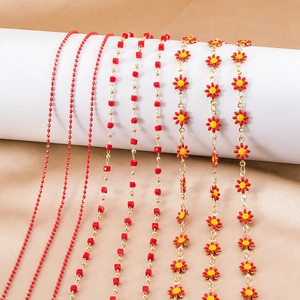 Detail view of red enamel bead and daisy flower copper chains for DIY jewelry making