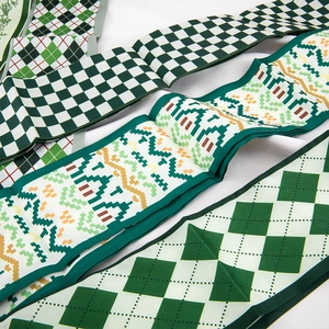 Detail van lange zijden sjaals met groen schaakbord en geometrische patronen
