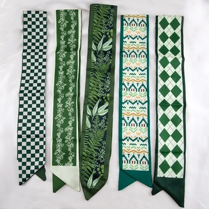 Detailopname van vijf groene zijden sjaals met elegante bloemen- en geometrische prints