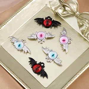 Macro shot of Gothic bat eye alloy charms for DIY jewelry making in a golden tray