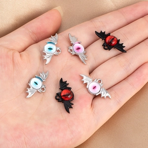 Detailed close-up of dark bat wing eyeball charms in various colors for DIY jewelry making