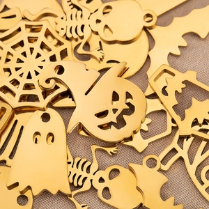 Detailaufnahme goldener Halloween-Anhänger aus Edelstahl wie Spinnen und Skelette