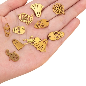 Goldene Halloween-Edelstahlanhänger mit Totenkopf und Spinne auf einer Hand