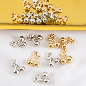 Macro-opname van gouden en zilveren kersenhanger op witte zijde voor DIY sieraden maken
