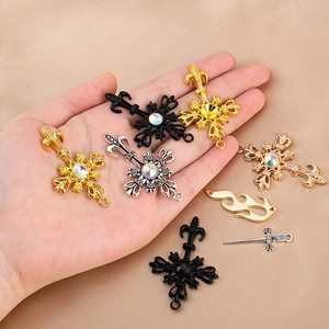Gros plan de divers pendentifs croix vintage en alliage avec strass pour bijoux DIY