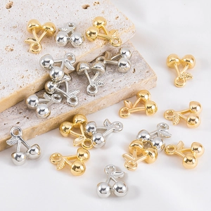 Gepolijste goud en zilver kers hangers voor DIY sieraden op steen achtergrond