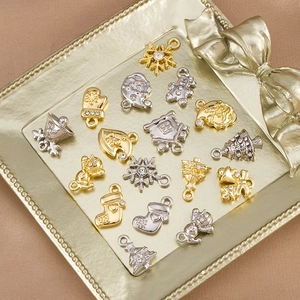 Detailed view of assorted Christmas alloy pendants for DIY jewelry in a gold metal tray