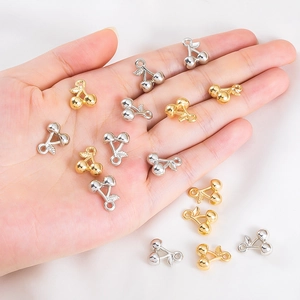Detailweergave van kersenhanger bedeltjes in goud en zilver op een handpalm gehouden