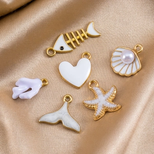 Pendentifs mer dorés avec émail blanc arête de poisson étoile de mer et coquillage