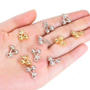 Gepolijste gouden en zilveren 3D kersenhangers voor DIY-sieraden in een handpalm