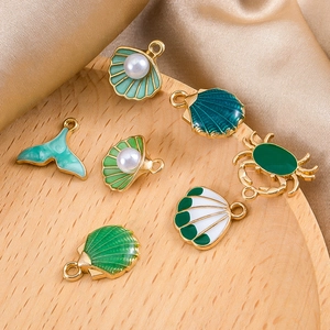 Groene zeedier hangers set met goudlegering schelpen en krab op zijden stof