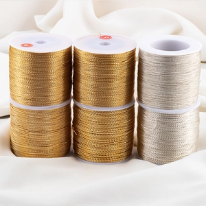 Makro-Detail von gold- und silbernen Metallfäden auf weißen Spulen für DIY-Projekte