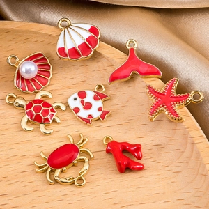 Dijes de la serie océano de aleación dorada con esmalte rojo para joyería artesanal