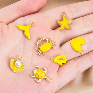 Details von gelben Emaille-Meeresanhängern wie Seestern und Schildkröte für DIY-Schmuck