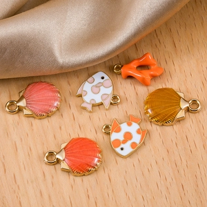 DIY ocean-themed enamel charms with starfish and shells on silk and wood