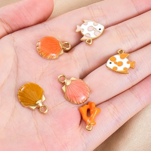 Detailed close-up of colorful ocean shell and fish enamel charms for DIY jewelry making