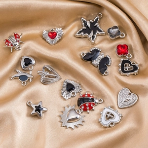 Variety of alloy charms with black and red enamel on elegant gold silk fabric background