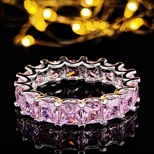 Anillo eternity con cristales rosa de corte princesa y banda plateada en superficie negra