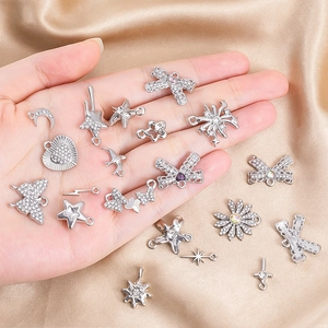 Close-up of assorted silver-tone alloy charms with zircons for DIY jewelry making