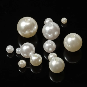 Macro shot of assorted round ABS faux pearl beads with pre-drilled holes for DIY jewelry