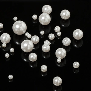 Detailed view of high-gloss white ABS imitation pearls in various sizes for DIY jewelry