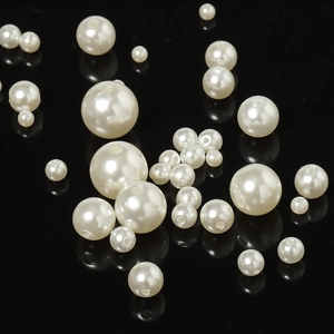 Detailed macro view of assorted cream white ABS faux pearls with pre-drilled holes