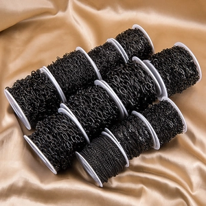 Macro detail of various black stainless steel DIY jewelry chains on white spools