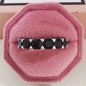 Bague éternité en argent avec pierres noires taillées dans un écrin en velours rose
