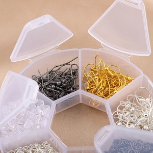 Détail de fournitures pour bijoux DIY avec crochets et anneaux dans une boîte de rangement