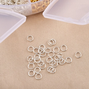 Détail macro d'anneaux de jonction argentés pour bijoux DIY avec boîte de rangement